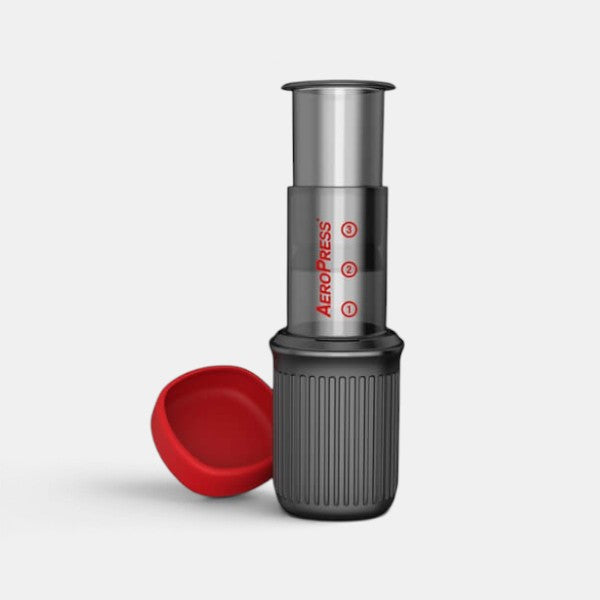 Bootlegger Coffee AeroPress Go portable coffee maker with red lid and black textured base on a white background