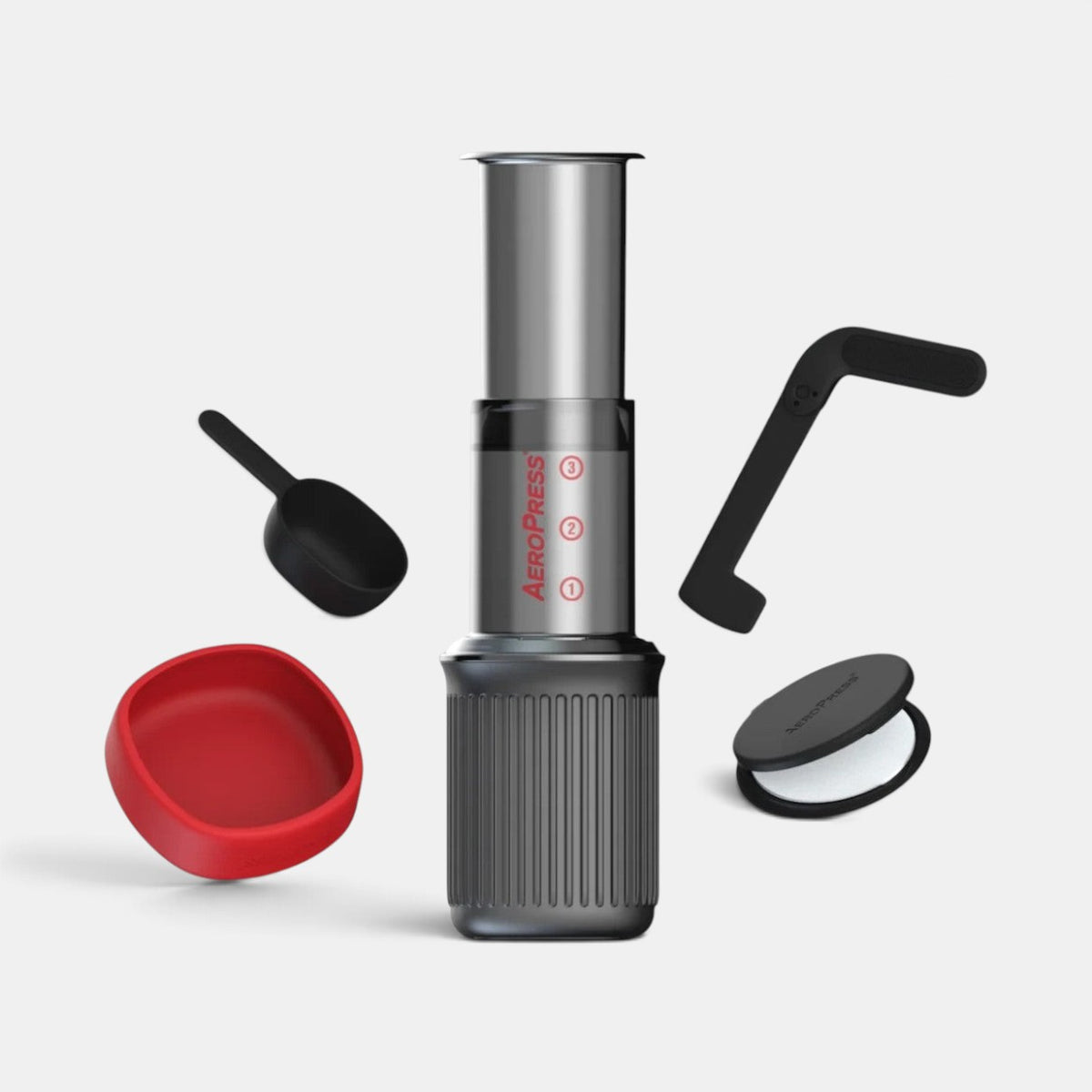Bootlegger Coffee AeroPress Go travel coffee maker with included scoop, stirrer, and filter cap in a studio setting