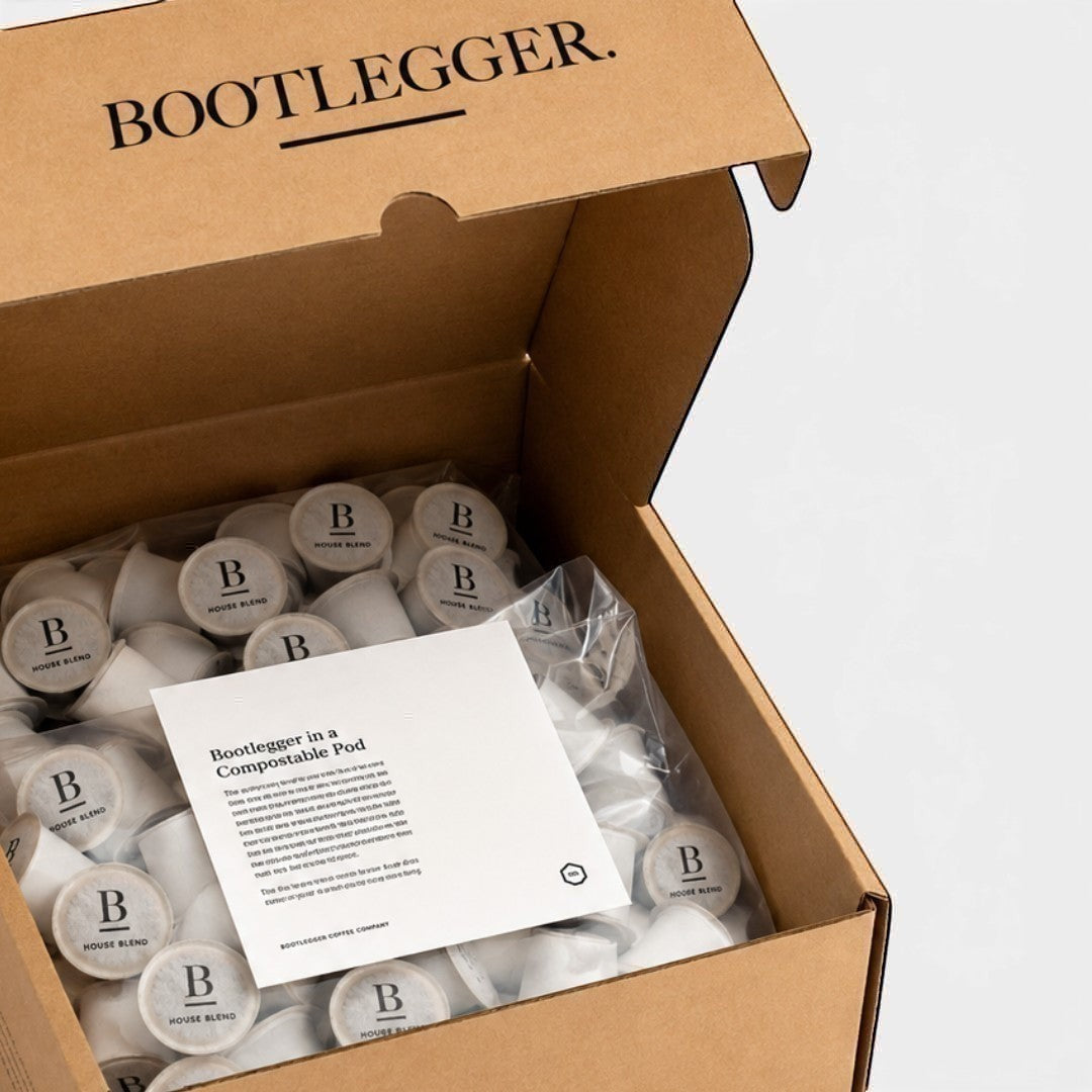 Bootlegger Coffee bulk box filled with 100 compostable House Blend coffee capsules and an informational card.
