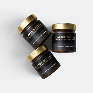 Three glass jars of Bootlegger Coffee Coffee Butter cashew nut and coffee spread with gold lids on white background
