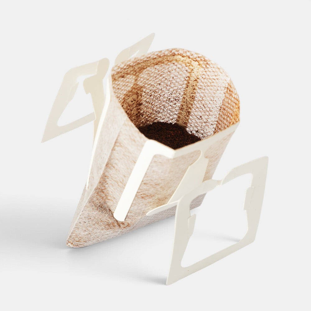 Bootlegger Coffee drip bag filled with ground coffee beans, featuring paper filter wings for easy brewing.