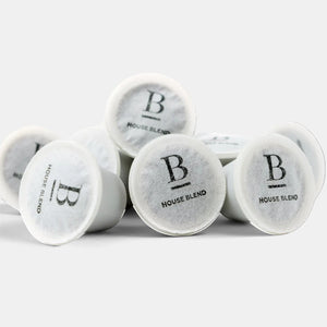 Bootlegger Coffee House Blend coffee capsules in a white pile on a clean background