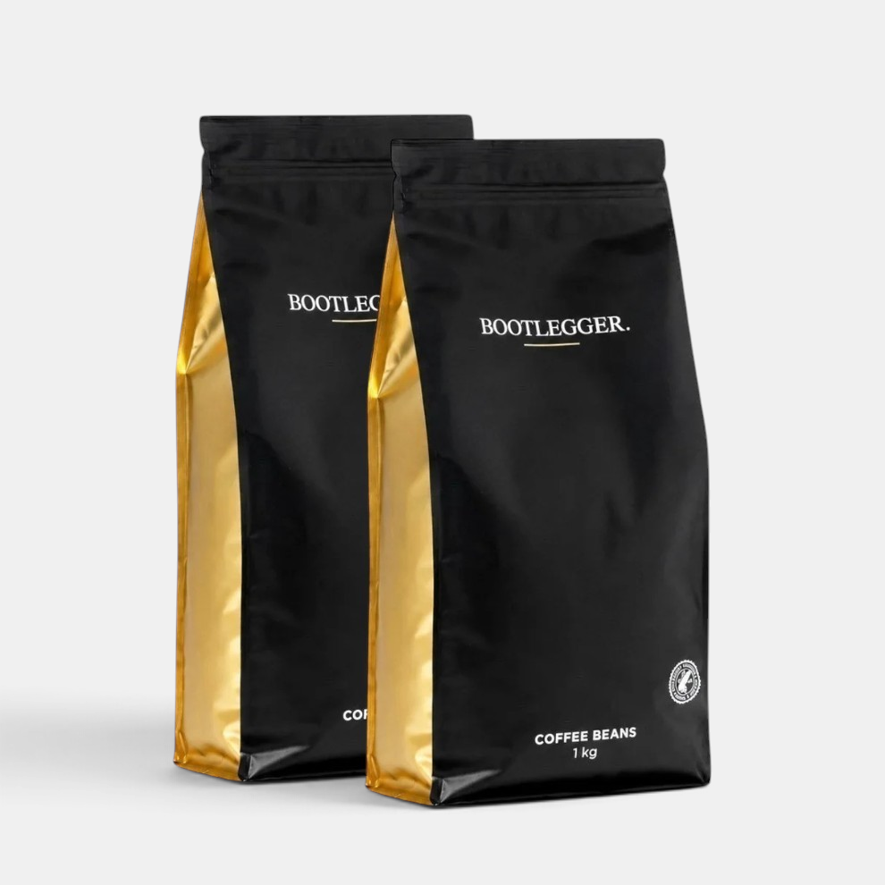 Two 1kg bags of Bootlegger Coffee House Blend coffee beans in black and gold packaging